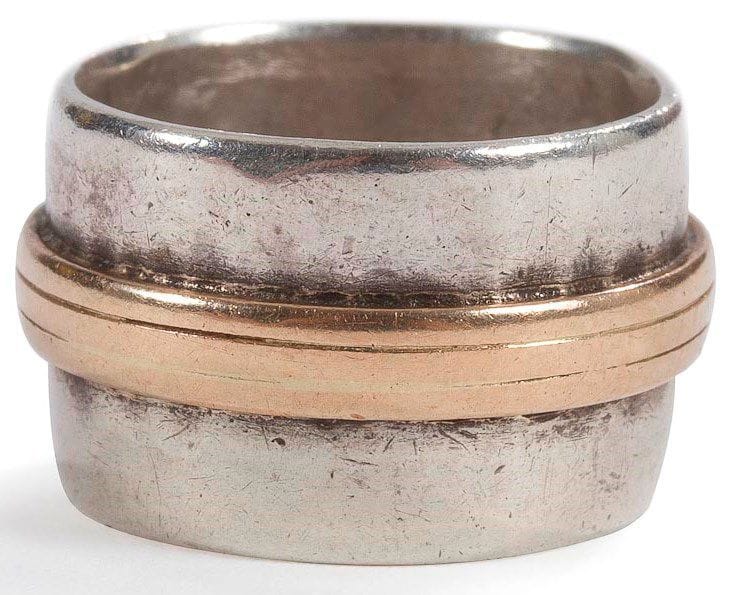 Jean DESPRES (1889-1980)
Bague moderniste en argent et or. L'anneau, à surface légèrement martelée, reçoit, sur tout son pourtour, un jonc rainuré. Signée J. DESPRÉS à la pointe à l'intérieur de l'anneau et porte les poinçons de Maître Orfèvre et de garantie. Poids: 9,9 g