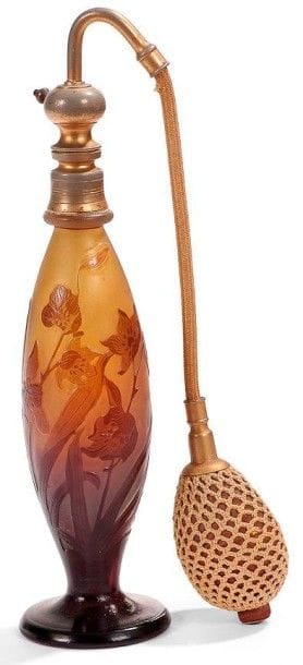 Établissements GALLÉ (1904-1936)
Vaporisateur, le corps ovoïde sur piédouche. Épreuve en verre multicouche au décor tournant dégagé à l'acide et traité prune, de tulipes et de muscaris, sur fond jaune intense. Mécanisme en métal doré. Usures à la dorure et poire altérée. Signé GALLÉ, en réserve gravé en camée à l'acide. Hauteur totale: 26 cm