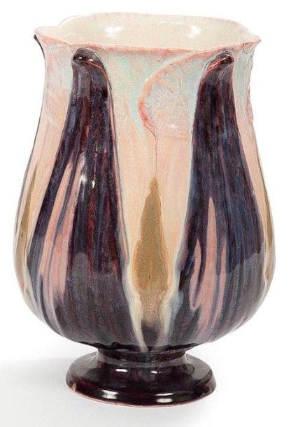 Émile GALLÉ (1846-1904)
Vase tulipe à col évasé reposant sur piédouche. Épreuve en faïence émaillée polychrome au décor de feuilles lancéolées en relief. Un éclat recollé en pourtour du col. Marqué du cachet E. GALLÉ Faïencerie à la Croix de Lorraine au revers. Hauteur: 20 cm Provenance: Succession Pierre Kjellberg