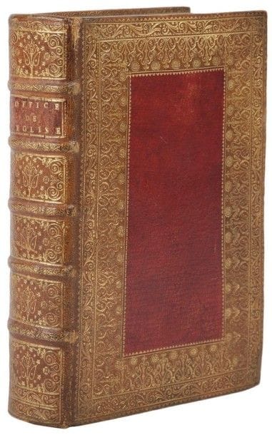 [RELIURE]. L'Office de l'Église En Latin & en François. Paris: Pierre le Petit pour la veuve de Claude de Hansy, 1723. - In-8, frontispice, (4 ff.), 69, vj pp., pp. 70-224, viij pp., pp. 225-677, (1 f.), 72 pp., 4 planches. Maroquin havane, large dentelle droite dorée en encadrement sur les plats, composée de filets, d'une roulette à dents de rat, d'une roulette de volutes et une autre à motifs de volutes alternés avec des tournesols à visage humain, large pièce rectangulaire de maroquin rouge au centre, bordée d'une roulette dorée, dos à nerfs orné, pièce de titre de maroquin rouge, roulette dorée sur les chasses, tranches dorées (reliure de l'époque).
Édition illustrée d'un frontispice non signé et de 4 planches gravées par Raymond d'après Champagne, Dulin, Coypel et Le Guide.
Très bel exemplaire en reliure parisienne mosaïquée ornée d'une large dentelle dont l'un des motifs représente un tournesol à visage humain.
Une note en anglais sur la première garde attribue cette reliure à Padeloup, exécutée pour le roi Louis XV, ce que nous ne pouvons pas confirmer. Il faut cependant noter que le fer au tournesol à visage humain est peu courant; ce motif était utilisé notamment par Luc-Antoine Boyer, relieur du roi de 1698 à 1733, mais le dessin du fer qui figure sur notre reliure est différent de ceux que Boyet utilisait (voir Jeanne-Marie Métivier, Luc-Antoine Boyet, relieur de l'Imprimerie royale (1704-1723), in: Revue de la BNF n° 12, pp. 41 à 46). Une autre note précise qu'une reliure identique a été reproduite dans le catalogue 104 de Breslauer (Fine bindings, n° 72). Ce fer est pour nous purement décoratif et l'absence notamment de fleurs de lys nous convainc que l'exemplaire n'est pas de provenance royale; sa qualité et sa rareté nous indique néanmoins une provenance importante.
Exemplaire dont les gravures ainsi que les gardes blanches ont été encadrées d'un filet doré à l'époque. Il provient de deux des plus importantes collections de livres du début