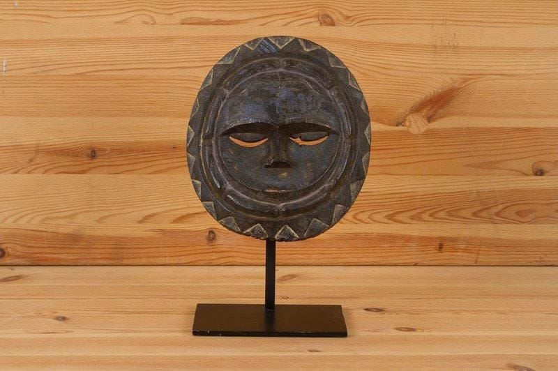 EKET (Nigéria)

Masque rond, entouré de deux sillons, traces de peinture. Entourage solaire, petite bouche, yeux en croissant de lune.
H.: 21cm - L.: 18cm