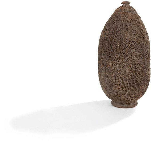 TUSSIAN / GOUIN (Burkina Faso)

Grosse jarre ovoïde.
Munie d'un couvercle, la surface hérissée de petites pointes aigües, cette terre cuite représente un autel personnel de la puissance «Tosia», protectrice contre les voleurs et les menteurs auxquels elle infligerait la lèpre. Les femmes dominantes du clan y enferment leurs objets de valeur. Patine brune et ocre rouge. Usures et cassures.

Provenance: M. Gédéon Bousquel, circa 1920/1930