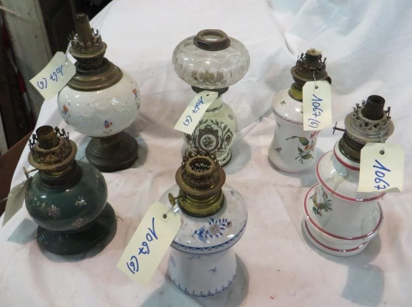 Ensemble de six lampes à pétrole, pied en porcelaine. (manques et accidents)
