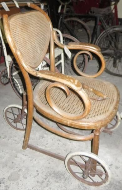 Ancien fauteuil roulant en bois et osier. (manques et accidents)