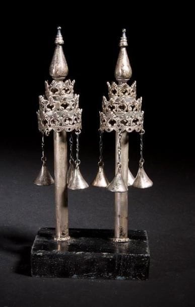 PAIRE DE RIMONIM MINIATURES Italie, XIXe siècle. Argent fondu et ajouré. Apparemment non poinçonnés. Hauteur: 15,5 cm Poids brut : 272 g
Troncs cylindriques surmontés de deux étages de tours octogonales ajourées et se finissant par un dôme. Posés sur un support de présentation en bois. Accidents et manques. Provenance: Vente Sotheby's Tel-Aviv du 15 Avril 1998, lot 159. Mots-clés: Judaica, Jewish, Hebrew, Judaïsme, Hébreu.
Pair of miniature silver Torah Rimonim or Finials. Italy, 19th century. Cast and filigree silver. No hallmark.