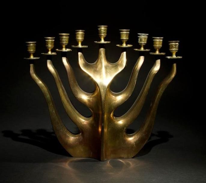 CHANDELIER DE HANOUCCA Années 1950. Bronze. Hauteur: 39.5 cm 
Chandelier aux formes mouvementées portant son shamash en son centre. Mots-clés: Judaica, Jewish, Hebrew, Judaïsme, Hébreu.
Hanukkah Candelabra. 1950s. Bronze.