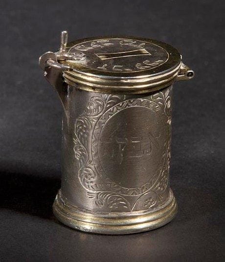 [CIRCONCISION] BOÎTE À POUDRE Allemagne, XVIIe ou XVIIIe siècle. Argent et vermeil gravé et ciselé. Hauteur: 4 cm - Diamètre: 3 cm Poids: 37 g
Boîte de forme cylindrique. Elle est gravée sur un côté du cylindre dans un encadrement ovale géométrique et feuillagé de la scène du sacrifice d'Isaac. Sur la face opposée, dans un encadrement également ovale, est gravé en hébreu le mot «poudre». Le couvercle porte des inscriptions qui sont probablement des abréviations. L'une d'entre elles a probablement pour sens: que son mérite protège tout Israël. L'autre n'a pas été déchiffrée.Cette boîte était destinée à contenir les poudres médicinales nécessaires à la circoncision. Mots-clés: Judaica, Jewish, Hebrew, Judaïsme, Hébreu.
Circumcision Box. German 17th or 18th century. Engraved/chased silver/silver-gilt.