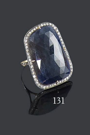 Bague en argent et en or 14K, ornée d'une lame asymétrique de saphir facetté dans un entourage de petits diamants. Tour de doigt: 54 - Poids brut: 10,2 g