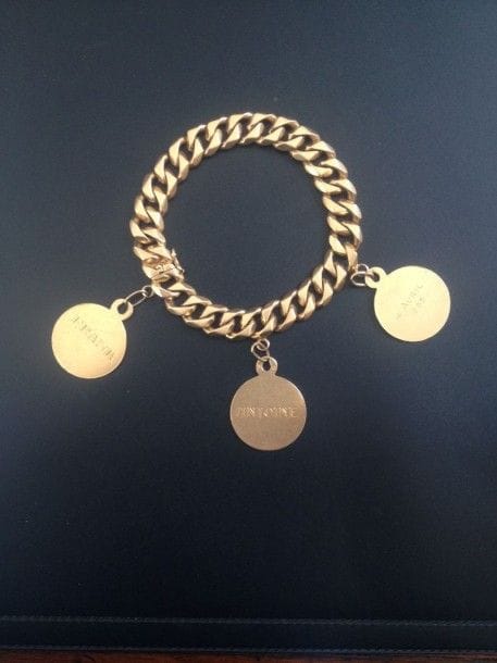Bracelet maillons gourmette en or 18K, retenant 3 médailles en pampille.
Poids : 75,21 g
