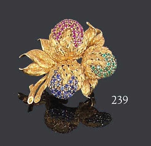 Broche en or jaune 18K amati, ornée de trois «fruits» pavés l'un de rubis, le second d'émeraudes, le troisième de saphirs. Hauteur: 4,5 cm - Poids brut: 16,2 g