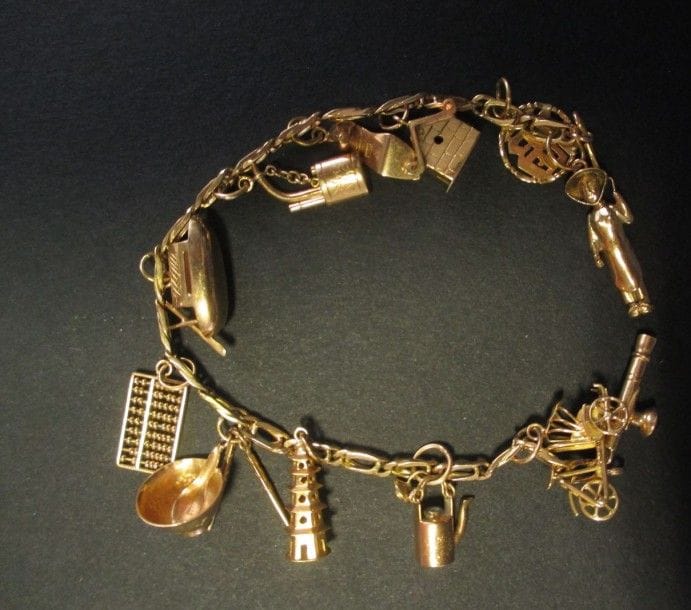 Bracelet en or jaune 18K retenant en pampilles 13 charms sur le thème de l'Extrême Orient, dont une paire de baguettes, un boulier, une pagode, une théière? Longueur: 18,4 cm - Poids: 22,6 g