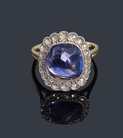Bague en or jaune et gris 18K, sertie d'un saphir pesant 6,58 cts entouré de diamants taillés en roses. Tour de doigt: 53 - Poids brut: 3,5 g (à ressertir)