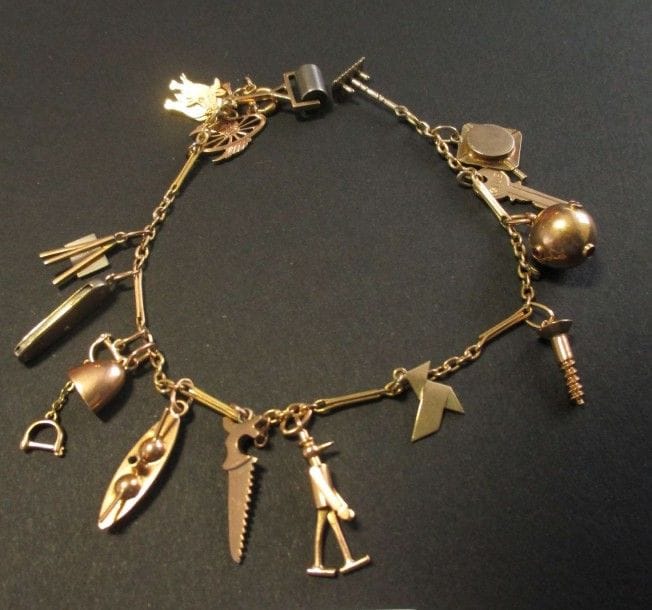 Bracelet en or jaune 18K, retenant en pampilles 16 charms variés. Longueur: 19,5 cm - Poids brut: 22,1 g