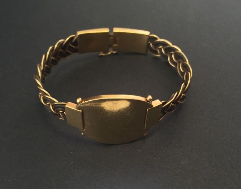 Bracelet ouvrant en or jaune 18K et cuir tressé. Longueur: 18,5 cm - Poids brut: 23 g