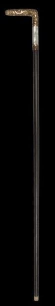 Canne à pommeau ciselé, Empire Ottoman, XXe siècle. 
Fût en bois, orné en partie supérieure de pans de nacre et pommeau de laiton ciselé d'arabesques végétales avec cartouche donnant les initiales PL.
Long.: 95 cm 
Cane with a carved handle, Ottoman Empire, 20th century