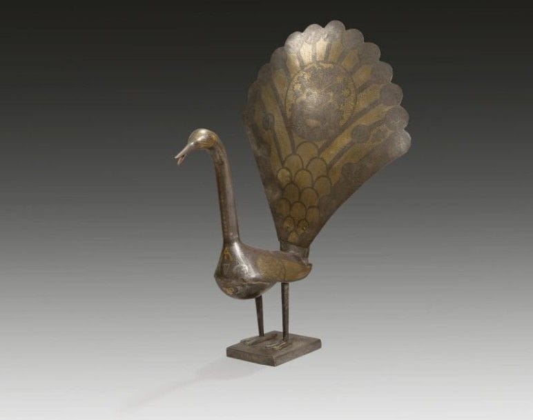 Paon en acier, Iran qâjar début XXe siècle.
Sur un socle carré, ronde-bosse à queue réticulée, incrusté d'or et d'argent soulignant le plumage sur la tête, les ailes et la queue présentant aussi un rondeau central meublé d'un vase fleuri et oiseau. 
Dim.: 52 cm
A steel peacok, Qajar Iran, 19th century
