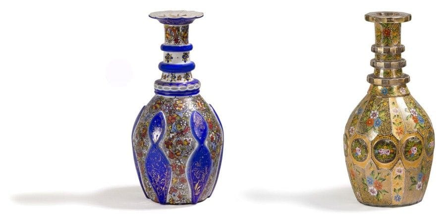 Deux carafes en verre, Iran XXe siècle. 
Panses ovoïdes à col annelé, sommées d'un bouchon conique, l'une en verre bleu, blanc et incolore, à décor floral peint en polychromie moulé de cartouches bleues, peintes d'arabesques en filets d'or ;- L'autre à pans coupés peinte en polychromie et dorée, d'un décor tapissant floral à dominante orangée et d'un frise de rondeaux à motifs de rose. 
Dim.: 42.5 cm ; 45 cm 
A paire of Bohemian bottles and tapering stoppers, Iran, 20th century