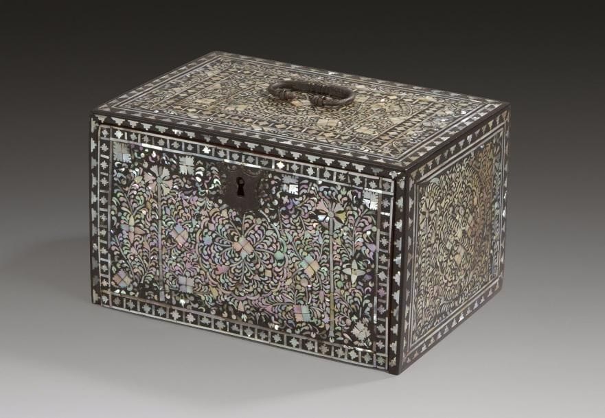 Cabinet en nacre, Inde, Gujarat, fin XVIe - début XVIIe siècles.
Coffret portatif rectangulaire à abattant en bois recouvert de bitume noir et incrustations de nacre colorée, ouvrant en façade sur cinq tiroirs. Entièrement décoré sur les faces et les côtés d'un médaillon polylobé à feuillage et c?ur de trèfle, entouré par deux ?illets sur fond d'entrelacs végétaux tapissant, dans un double encadrement de losanges et triangles. Intérieur peint de bouquets de fleurs jaunes sur fond orangé et prise des tiroirs en forme de goutte en laiton. 
Dim.: 22 x 15 x 13 cm

A mother-of-pearl cabinet, India, Gujarat, late 16th-early 17th century
Aux XVIe et XVIIe siècles, ces objets luxueux étaient réalisés au Gujarat, autour d'Ahmenabad, Cambay, Surat et plus à l'ouest à Thatta. Créés pour de riches indiens ils étaient aussi destinés à l'exportation pour des Européens. En 1529, le roi de France reçut un lit en nacre et un coffre incrusté de nacre faisait partie de l'inventaire de la collection de l'Électeur de Saxe de 1602. Ce cabinet appartient à un groupe de pièces, en bois recouvertes de bitume incrusté de nacre au décor végétal, géométrique ou figuratif dont l'inspiration japonaise ou coréenne reste incertaine. Du fait de la nature fragile des matériaux, il reste une trentaine d'objets de forme variée, coffrets, des écritoires, des cabinets, un trône, des étagères et des plateaux de jeux.

Pour des objets similaires: Victoria and Albert Museum, Londres, n° inv. 155-1866 ; catalogue de vente de Christie's, Londres: 12/10/2004, n°199 ; 31/03/2009 n° 214 et 7/04/2011 n°225
Pour une étude: Exposition Via Orientalis, Galeries de la CGER, Bruxelles 1991, p. 115 - A. Jaffer, Luxury Goods from India, Victoria and Albert Museum, Londres, 2002, p. 58-59 et S. Digby, «The motherof-pearl inlaid furniture of Gujarat», Facets of Indian Art», 1986, pp. 213-221.
