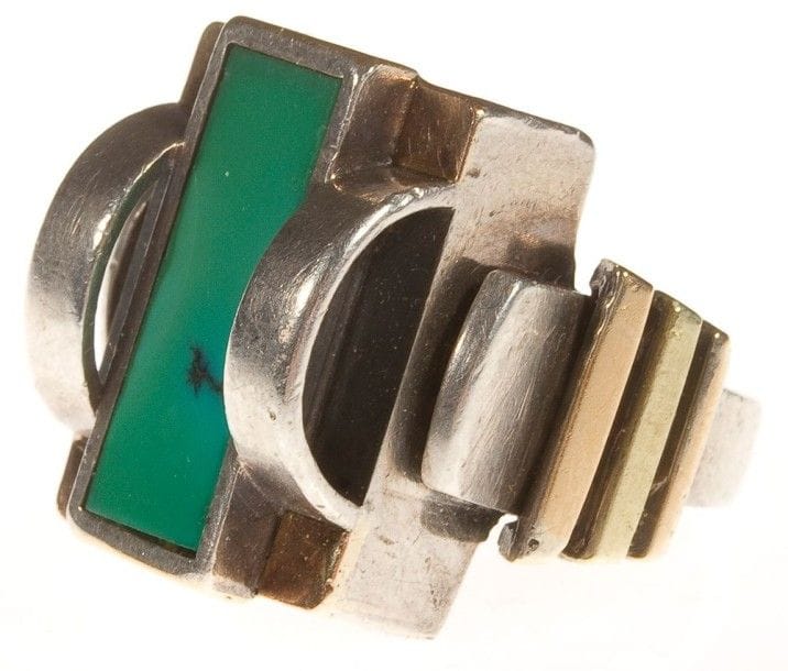 Jean DESPRES (1889-1980)

Rare bague moderniste en or jaune, or rose et argent.
La plateforme constructiviste, aux motifs latéraux de deux arcs de cercle, reçoit un cabochon rectangulaire en turquoise.
L'anneau est orné de trois barrettes de sections croissantes.
Signée J. DESPRÉS à la pointe à l'intérieur de l'anneau et porte le poinçon de garantie.
Poids: 16,18 g
Provenance:
- Madame Jeanine Patouret (Avallon ? France), ?uvre acquise directement auprès de l'artiste.
- Par descendance."