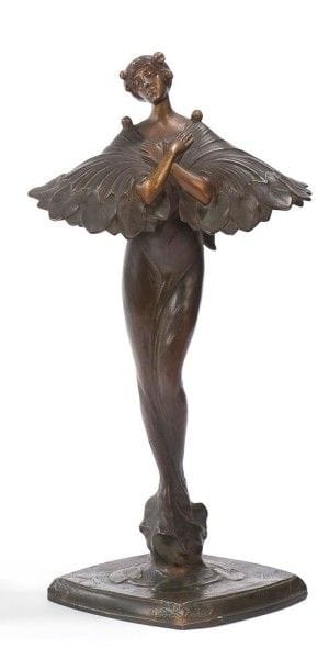 Jules JOUANT 

Femme à l'Étole nénuphar, circa 1900
Haute sculpture formant lampe, les sources lumineuses sous l'étole.
Épreuve en bronze patiné vert nuancé, brun et doré.
Fonte d'édition ancienne, époque Art Nouveau.
Signée JOUANT et porte le cachet de fondeur Eug. BLOT Paris sur la terrasse.
Hauteur:53 cm
Exposition et bibliographie:
Lumières, je pense à vous - Galerie du CCI du Centre Georges Pompidou (Beaubourg) du 3 juin au5 août 1985. Modèle à rapprocher présenté sous le n° 159 bis et reproduit au catalogue page 145."