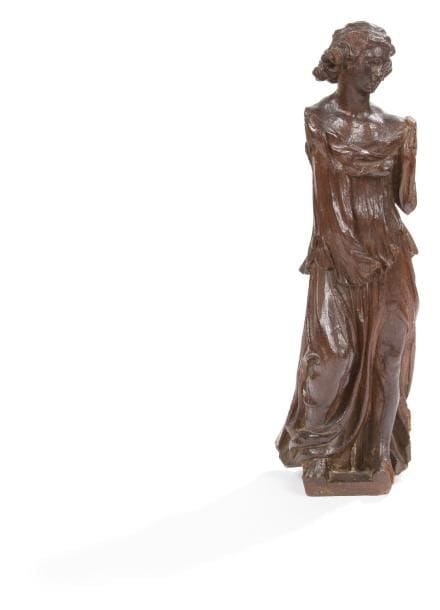 Ange en chêne sculpté en ronde-bosse, coiffure retenue par un bandeau, tunique fendue laissant apparaître la jambe gauche. XVIIe siècle. H.: 44 cm.(ailes et bras manquants, petit accident à la chevelure)