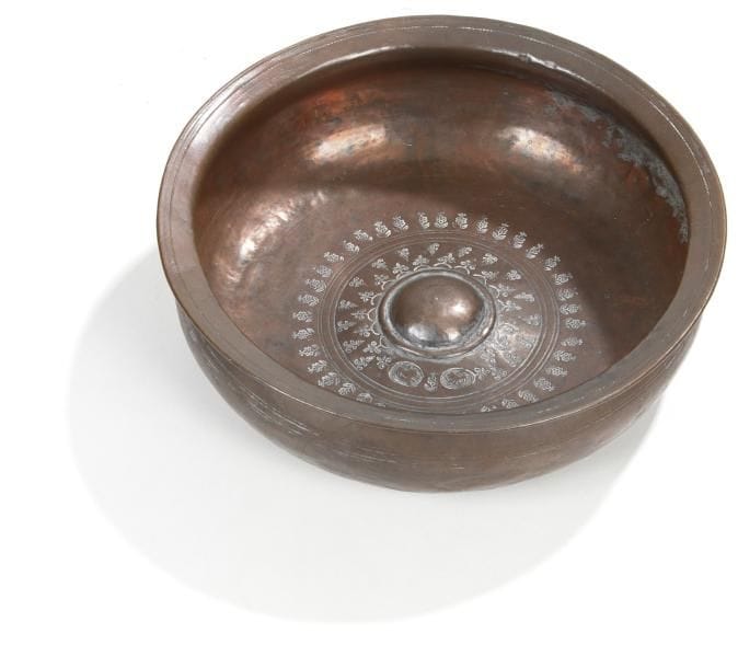 Bassin de braséro en cuivre à décor poinçonné de tiges fleuries et de lions autour d'un ombilic. Perse, XIXe siècle. D.: 24 cm