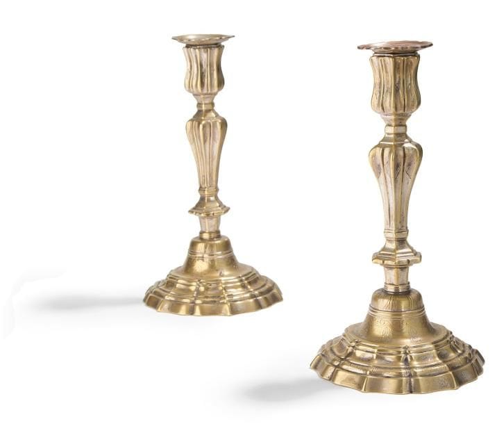 Paire de flambeaux en bronze anciennement argenté, mouluré et gravé de feuillages. Époque Louis XV (usures). H.: 26 cm