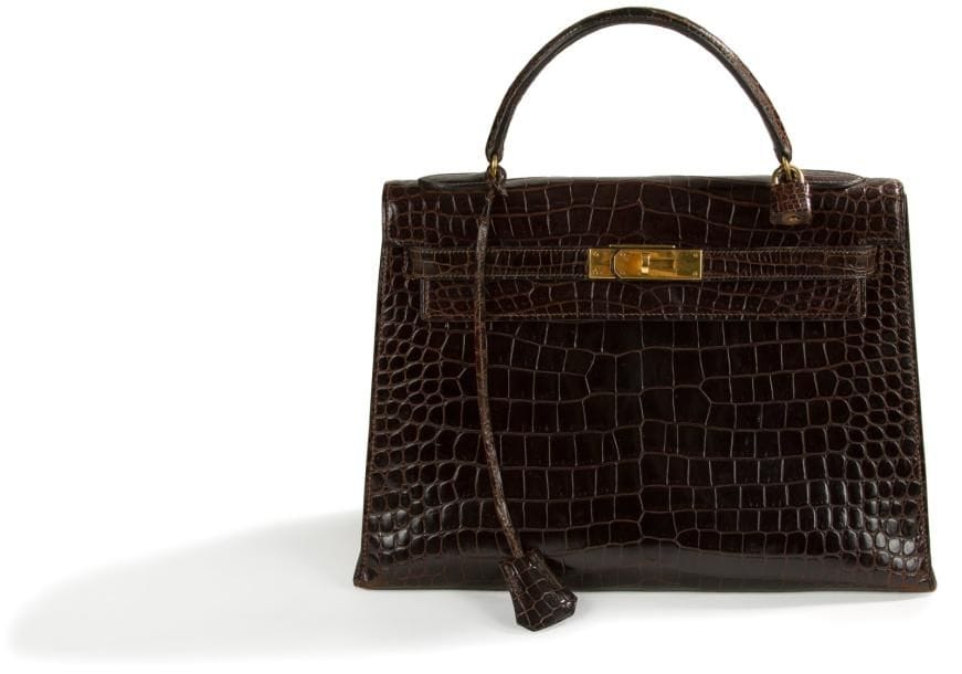 Sac Kelly en crocodile Porosus marron. Fermoir et attaches en plaqué or. Clefs et cadenas. Dans sa housse Hermès. Le CITES délivré en 2015 sera remis à l'acheteur. H.: 32 cm. (Petites usures aux coins inférieurs)