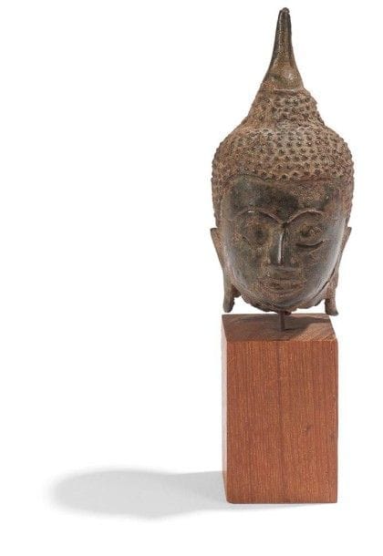 THAILANDE, Ayuthya - XVIIe/XVIIIe siècle

Petite tête de bouddha en bronze à patine brune, les yeux mi-clos, la coiffe surmontée de l?ushnisha.
(Gerces).
H.: 9,5 cm