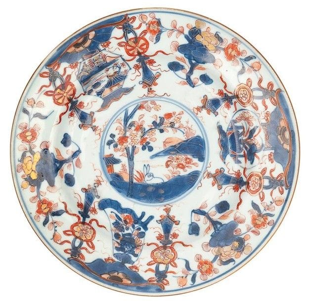 CHINE - EPOQUE KANGXI (1662 - 1722)

Assiette en porcelaine blanche décorée en bleu sous couverte, rouge de fer et émail or d?un médaillon de paysage entouré de fleurs.
D.: 22 cm