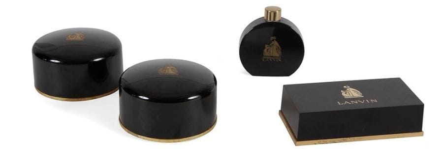 Jeanne LANVIN

Arpège, parfum créé en 1927
Intéressante suite de deux boîtes circulaires à talc parfumé (complètes), d'un saupoudreur à talc et d'un coffret à savonnettes (complet). Plastique noir rehaussé à l'or, décor gravé du sigle de A.A. Rateau. Marqués Lanvin.
Boîtes circulaire: D. 13 cm - H. Saupoudreur: 10 cm - Boîtes à savonnettes: 4,5 x 17 x 8,5 cm