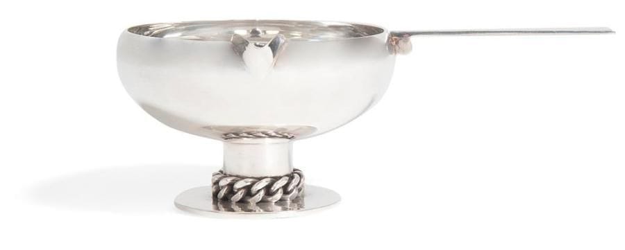 Jean DESPRES (1889-1980)

Élégante saucière en métal argenté. Base circulaire martelée et ornée d'une gourmette à maillons plats. Prise, ornée d'un cylindre, est à surface martelée. Signée J. DESPRÉS à la pointe et porte le poinçon de Maître Orfèvre au revers de la prise. 7 x 20,5 x 13 cm