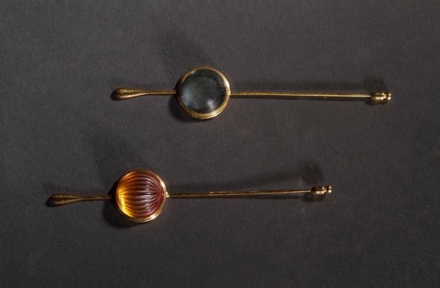 MAISON LALIQUE d'après un modèle de Marie-Claude LALIQUE (1935-2003)

Cabochon, modèle créé en 1991
Suite de deux épingles à chapeau en cristal bleu clair et orange strié sur montures en métal doré. Chaque épingle signée LALIQUE France au revers des platines. L. 13 cm