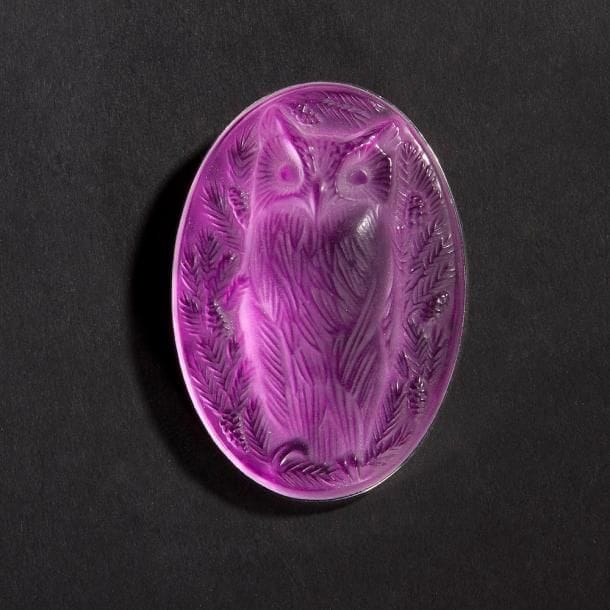 MAISON LALIQUE d'après un modèle de Marie-Claude LALIQUE (1935-2003)

Hibou
Broche en cristal moulé-pressé, achevé satiné, sur tain miroir rose vif. Platine en métal argenté. Signée LALIQUE France au revers de la platine. L. 6,5 cm