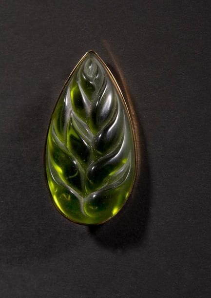 MAISON LALIQUE d'après un modèle de Marie-Claude LALIQUE (1935-2003)

Héliconia
Broche en cristal vert sur monture en métal doré. Signée LALIQUE France au revers de la platine. L. 5,5 cm