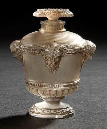 RENE LALIQUE (1860-1945)

Bouquet de faunes, moyen modèle, dit aussi Vasque Louis XVI, pour GUERLAIN, au registre des modèles le 7 août 1925
Flacon à parfum (Réf. Marcilhac Guerlain - 1 p.940). Corps en verre blanc soufflé-moulé. Bouchon en verre blanc moulé-pressé. Patine grise d'origine. Marqué GUERLAIN Paris en relief sur l'urne. Porte le numéro 463 et la lettre H, gravés sous la base. H. 10 cm