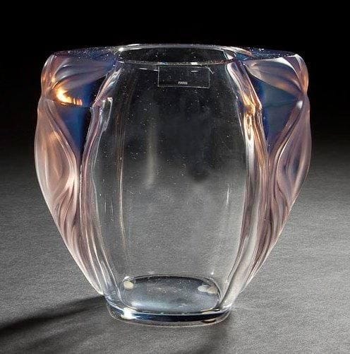 MAISON LALIQUE d'après un modèle de Marie-Claude LALIQUE (1935-2003)

Clématites, modèle créé en 1990
Vase en cristal soufflé-moulé, les anses en cristal opalescent lilas collées à chaud. Vendu dans son coffret d'origine. Signé LALIQUE ® France en lettres cursives, à la pointe, sous la base. H. 16,8 cm