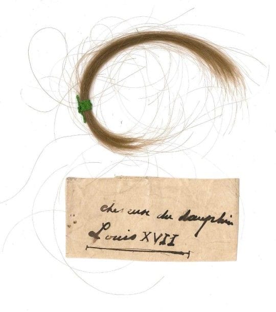 [LOUIS XVII (1785-1795) fils de Louis XVI et de Marie-Antoinette]
Mèche de cheveux, avec note manuscrite Mèche de cheveux blonds, liée par un fil vert, avec étiquette d'écriture ancienne: «cheveux du dauphin Louis XVII»