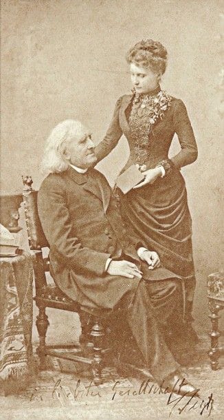 Franz liszt (1811-1886)
Photographie avec dédicace autographe signée, [1885]; 18 x 10 cm à vue (encadrée) Portrait en pied, de trois quarts, du compositeur vers la fin de sa vie, prise à Budapest en 1885 par Koller (Ernst Burger, Franz Liszt, Fayard, 1988, n° 603). Liszt est assis sur une chaise, un crayon dans la main droite; à sa gauche, une belle jeune femme debout à ses côtés, son élève pianiste Lina Schmalhausen (1864-1928), lui tend son carnet d'autographes. Liszt a inscrit cette affectueuse dédicace: «In liebster Gesellschaft F. Liszt»(*)
