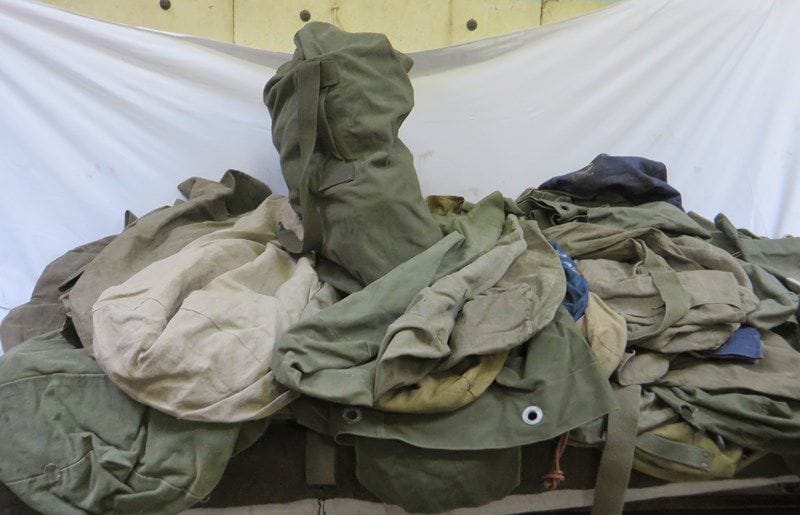 Un fort lot de sacs de voyages, sacs de transport, musettes, pantalons, et toiles diverses