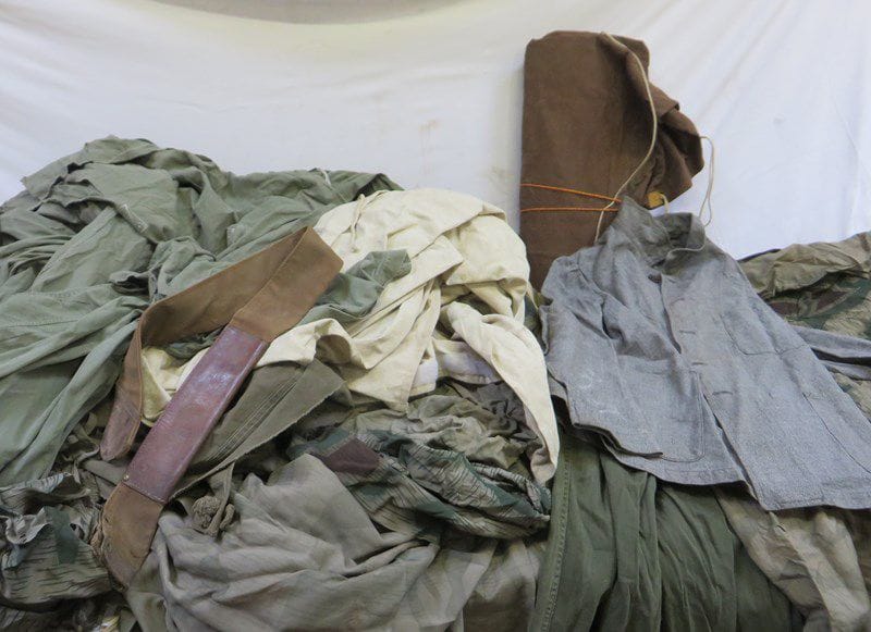 Lot comprenant nombreuses toiles de tentes camouflées kaki, quelques pantalons, et vestes