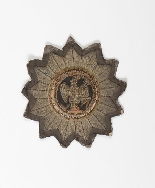 Rare plaque en canetilles, velours et fils dorés de la loge «le Phoenix» motif central avec le soleil rayonnant, le compas-équerre et en ceinture «La T:.R:.Loge du Phoenix». Célèbre loge du Rite d'Hérédom créée par les Maçons français revenus de St. Domingue.
Époque Empire.
H.: 11 cm