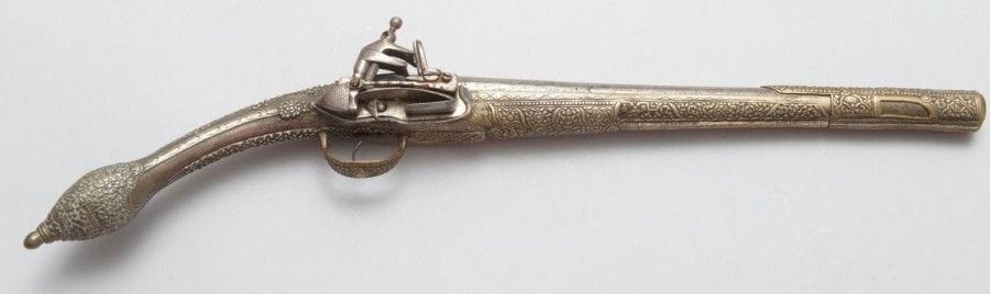Grand pistolet à silex. 
Canon rond à pans au tonnerre. Platine à la Morlaque. Crosse et fût en bois entièrement recouvert de laiton argenté, gravé et ciselé. Pontet et fausse baguette à décor en suite. 
B.E. Balkans. Première partie du XIXe siècle