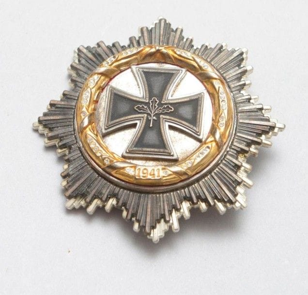 ALLEMAGNE
DEUTSCHES KREUZ.
Plaque du modèle après-guerre «Or et brillants». 
En métal argenté et doré. Attache poinçonnée «41». 
Hauteur: 6,5 cm
T.T.B