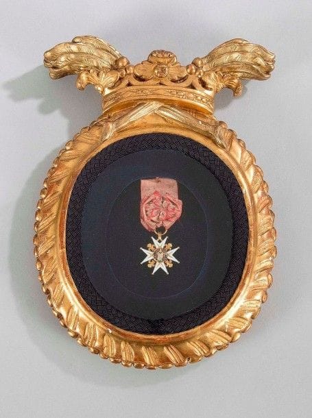 FRANCE 
ORDRE DE SAINT-LOUIS, instauré en 1693. 
Étoile de chevalier d'époque Louis XVI. 
Or et émail (éclats). Ruban ancien à bouffette. 
Poids brut: 20.08 g 
Sous verre, présenté dans un cadre doré à décor de couronne de marquis. 
T.B