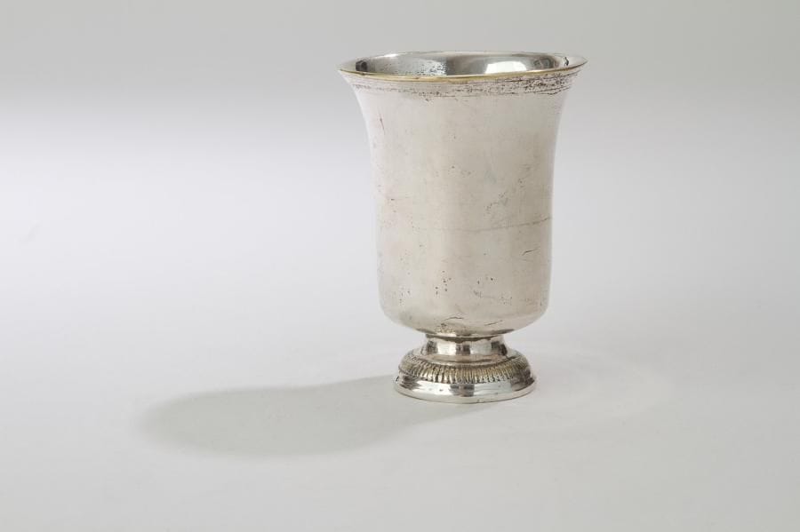 Timbale en métal plaqué reposant sur un piédouche à bordures de godrons, coupe terminée par un rang de filets.
Plaquage usé mais non réargenté.
XVIIIe siècle
Hauteur: 10,9 cm