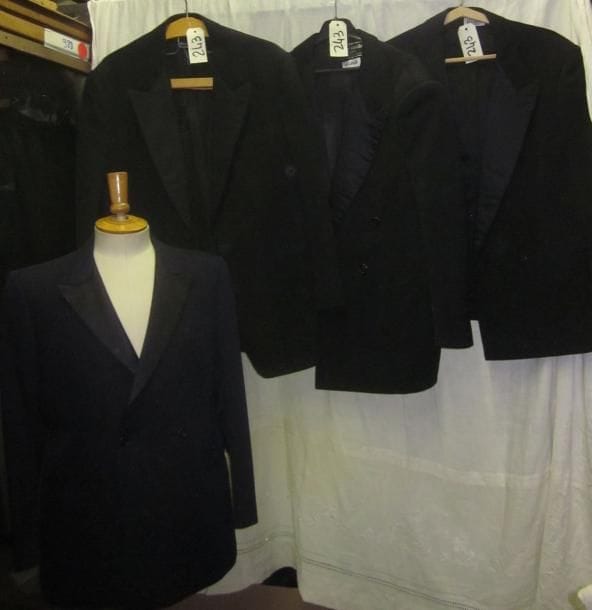 Une quinzaine de vestes noires de smoking pour homme, style XXe.
