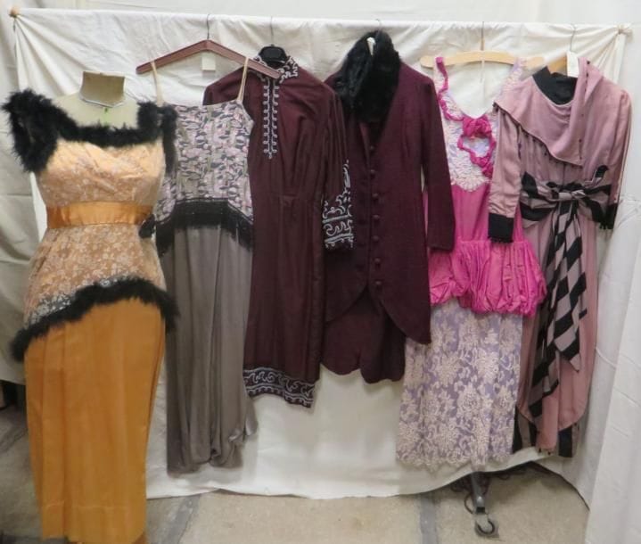 Six robes ou ensembles pour femme, style début XXe. Matières: dentelle, lainage et soie.