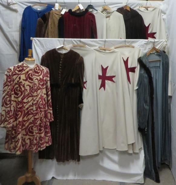 Quatorze tuniques, manteaux ou capes longues pour homme, style Moyen-Âge. Matières: lainage, soie et velours.