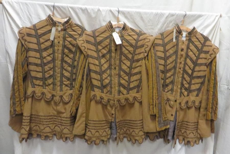 Trois vestes ocres à galon doré pour laquais, style Moyen Âge. Matières: lainage et velours.